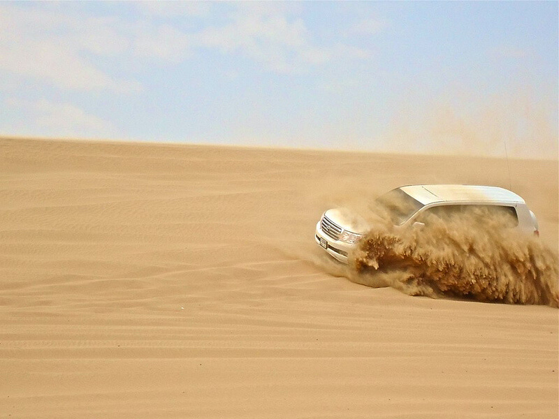 car driving on sand dunes