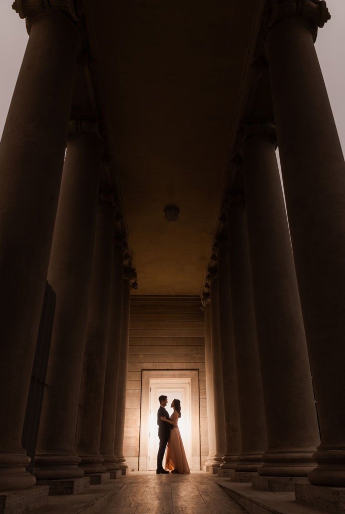Couple stands against door in columns