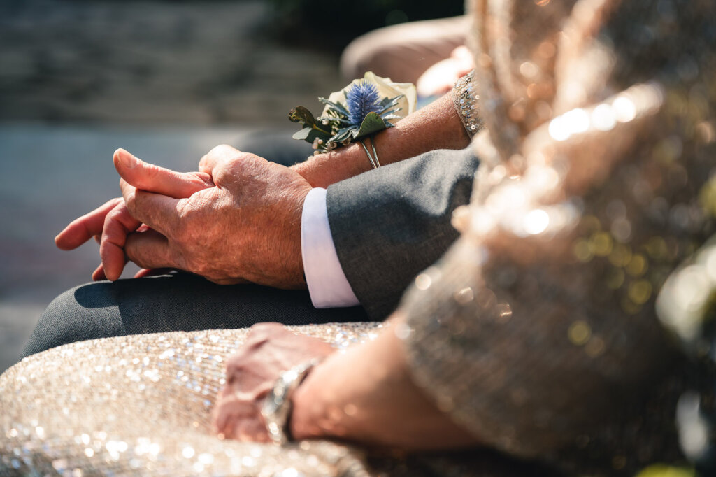 Couple holds hands at wedding featured artist wedding photographer P.J. Oswald